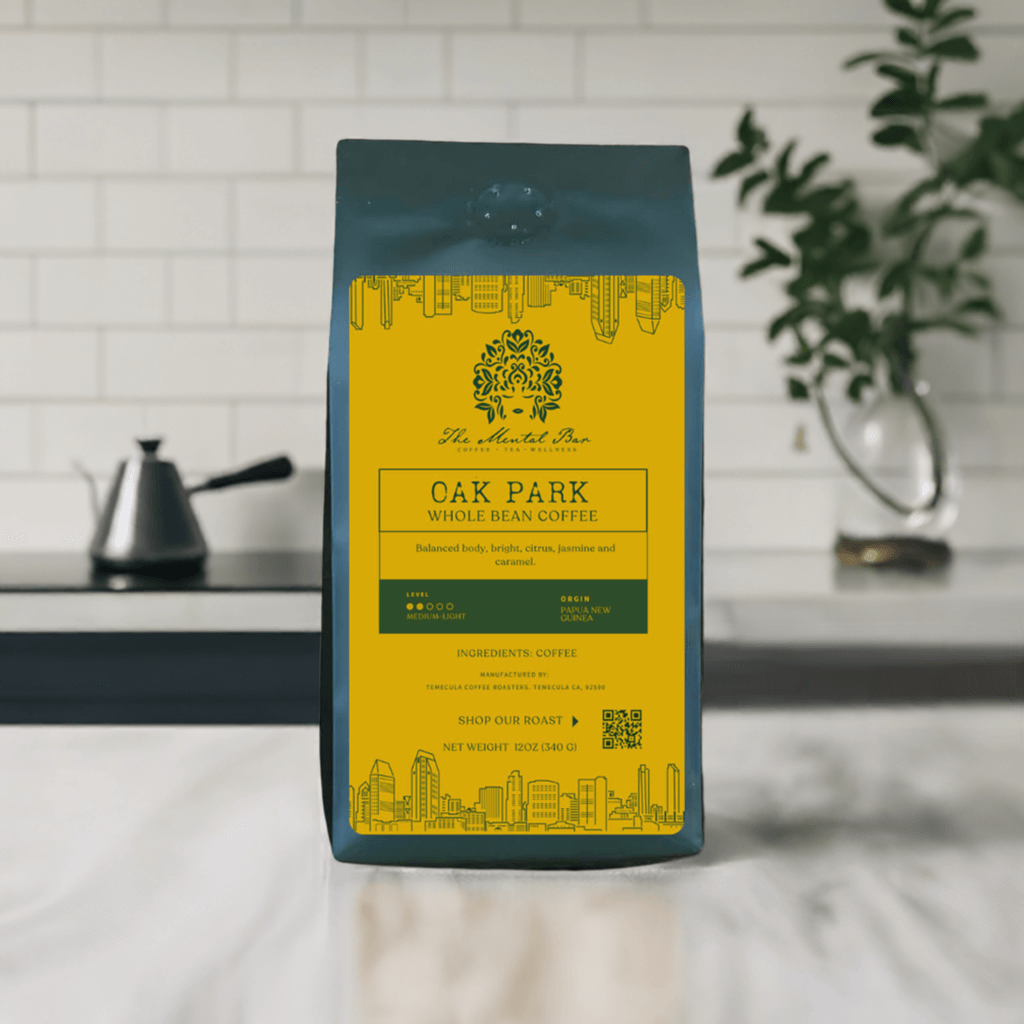 A pack of Oak Park whole bean coffee by The Mental Bar, with branding and product information on the packaging, set against a kitchen background.